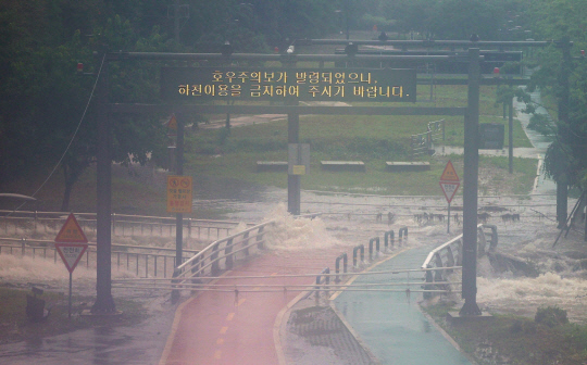 서울 전역에 호우주의보가 발효되는 등 본격적인 장마가 시작된 13일 서울 구로구 도림천으로 인근 빗물펌프장의 물들이 유입되고 있다.   연합뉴스